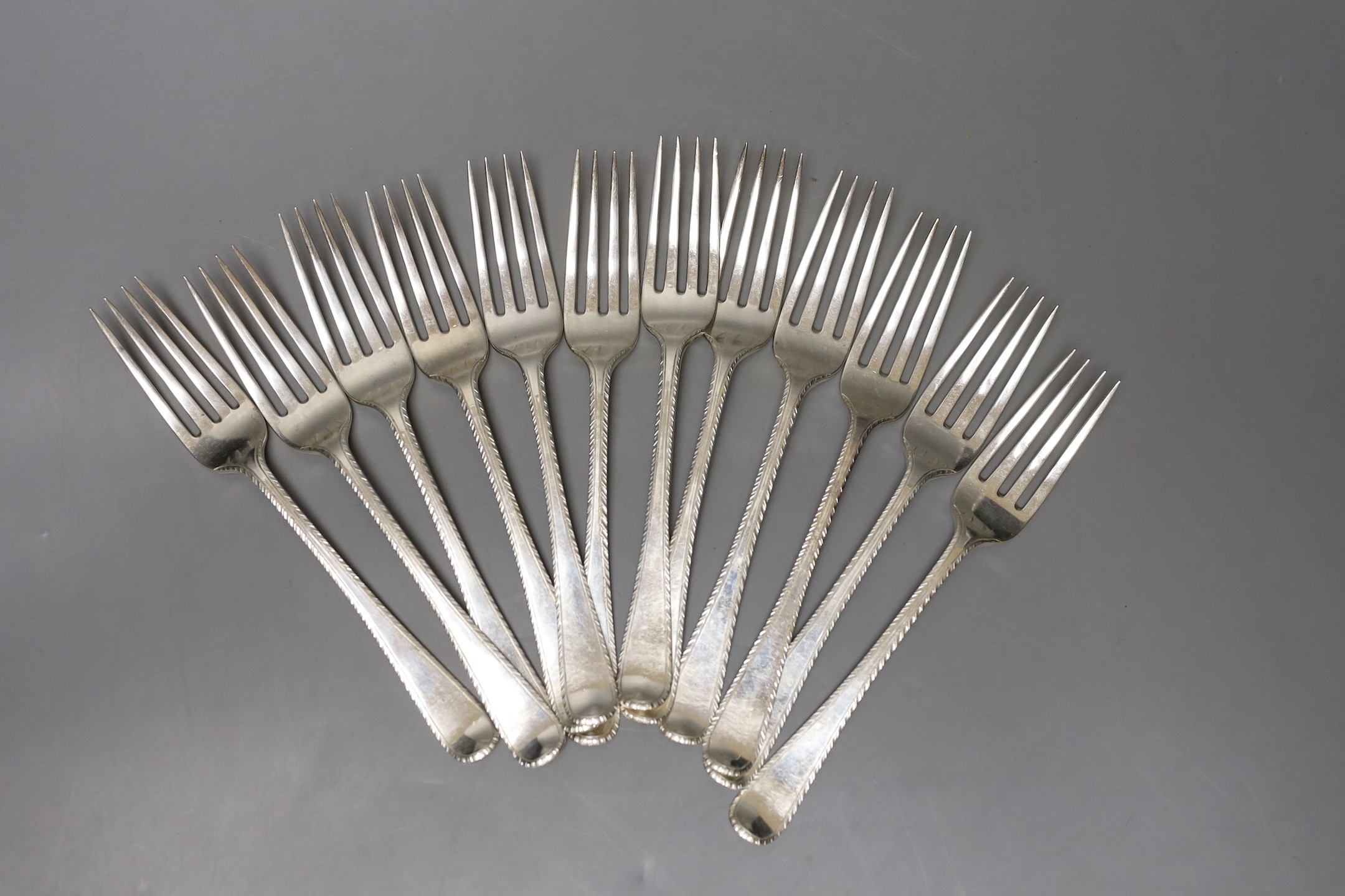 A set of twelve late George III silver Old English feather edge pattern table forks, indistinct maker's mark, London, 1818/19